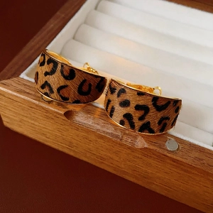 Chic leopard print hoop earrings with gold-plated metal base on white jewelry box padding