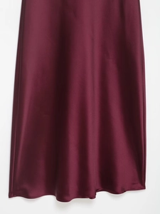 Detail view of burgundy satin midi dress fabric showing silky texture and elegant drape