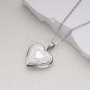 Detailed view of an openable heart-shaped locket necklace with floral relief patterns