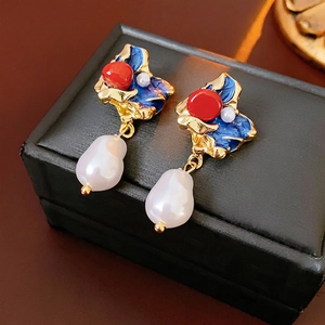 Vintage enamel baroque pearl drop earrings in gold setting with blue waves on black leather