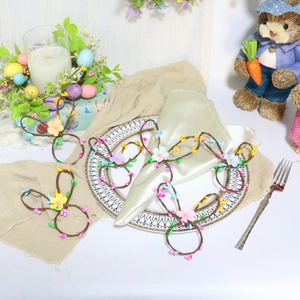 Easter bunny ear napkin rings with artificial flowers and berries on a white table setting