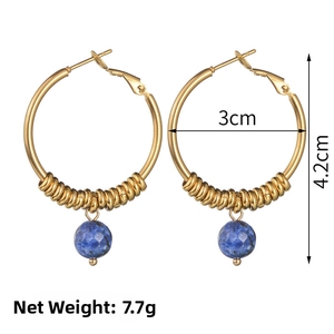 Macro detail of 14k gold U-shaped earrings with faceted blue lapis stone beads