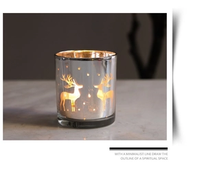 Detail of silver elk glass candle holder with warm glowing stars on white marble
