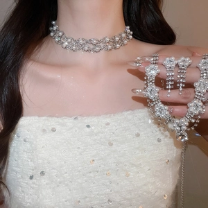 Detail of luxury teardrop pearl and rhinestone necklace set worn by a model