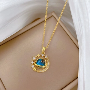 Primo piano dettagliato di una collana a pianeta dorata con nucleo blu e piccoli cristalli