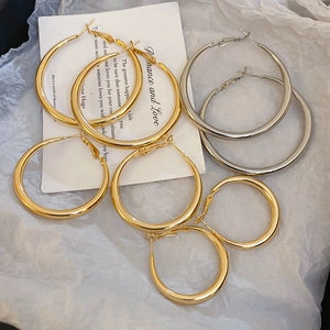 Detailed view of gold and silver hoop earrings on a poetic card with crumpled paper