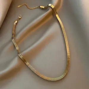 Golden fish scale snake chain bracelet with reinforced sleeve connector on silk background