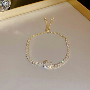 Detail of gold zircon heart bracelet showing sparkling round diamond and pull adjustment buckle