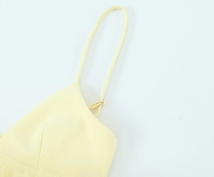 Dettaglio delle spalline regolabili e dello scollo a V di un top in tulle giallo pallido