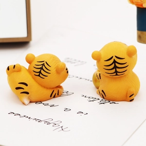 Macro view showing the back details of two yellow resin tiger figurines for car decor