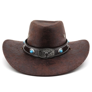 Gros plan d'un chapeau de cow-boy marron avec perles turquoise et boucle tête de taureau