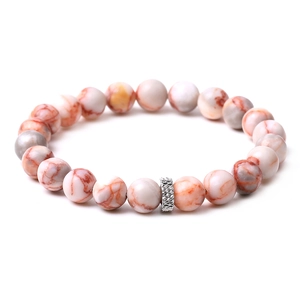Detailed macro view of white turquoise beads with natural red veins and a silver metal spacer
