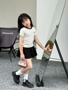 Vue détaillée d'un ensemble fille avec t-shirt à pois, jupe plissée et mini sac coquille
