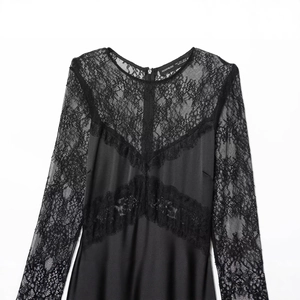 Elegant black long-sleeved maxi dress featuring delicate lace patchwork and smooth fabric