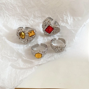 Detailed macro view of four hammered texture silver rings with colorful resin gemstones