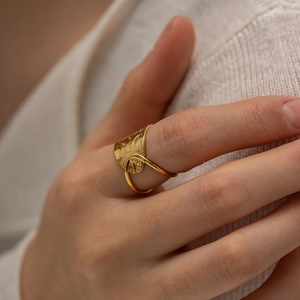 Irregular hollow geometric gold ring with hammered texture on a female model hand