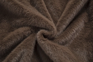Macro texture of premium dark brown faux fur fabric with soft plush velvet finish