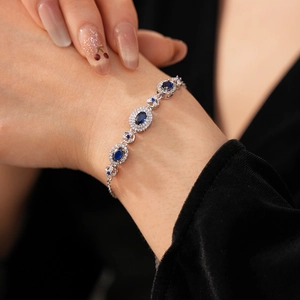 Close-up of a vintage silver bracelet with blue oval gemstone on a female wrist