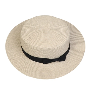 Detailed view of boater straw hat with wide brim and black ribbon bow decoration