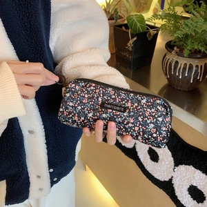 Detailed view of vintage black floral corduroy pouch with zipper and merciparis label