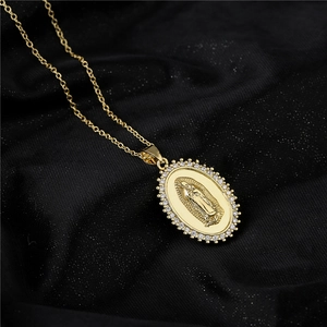 Golden Virgin Mary oval pendant necklace with sparkling cubic zirconia on black silk
