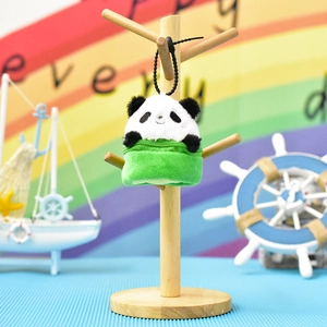 Close-up of a cute plush panda keychain pouch on a wooden display stand