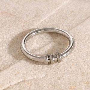 Macro view of minimalist silver stainless steel fidget ring with three moving loops