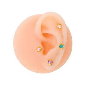 Vue détaillée de boucles d'oreilles pierres rondes colorées sur un modèle d'oreille en silicone