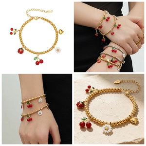 Détail du bracelet en perles avec breloques cerise, marguerite et coccinelle en or 18k