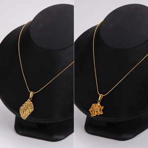Minimalist gold stainless steel necklaces with leaf and flower pendants on black mannequin