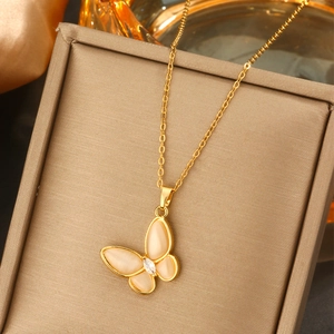 Detailaufnahme der goldenen Schmetterlingskette mit Flügeln aus Opalglas auf Schmuckkästchen
