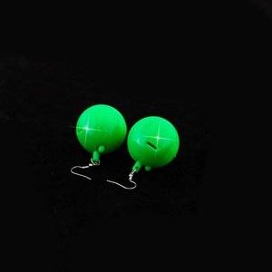 Macro shot of green disco ball earrings with reflective surface and silver ear hooks