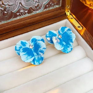 Dettaglio di orecchini a fiore blu tie-dye con cristallo in scatola vintage