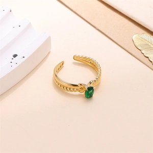 Detail of a gold adjustable ring with an oval green zircon and twisted rope band texture