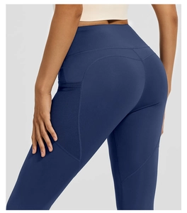 Detail of high waisted yoga leggings in navy blue with functional side pocket and curved seams