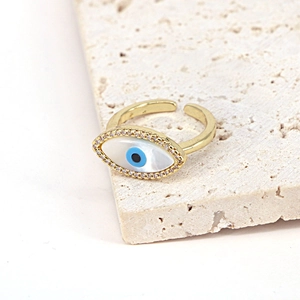Detail of evil eye ring featuring shell inlay, blue zircon center and gold plating