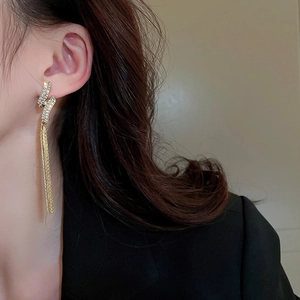Macro detail of elegant gold tassel earrings with shimmering cubic zirconia stones