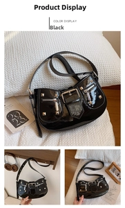 Detail of black patent leather motorcycle bag with silver studs and metal zippers