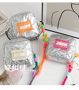 Gros plan sur le mini sac matelassé argent métallique avec cordon tressé coloré