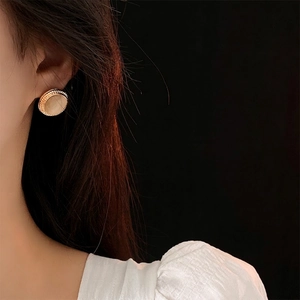 Retro round cat-eye stone earrings with gold twisted rope edge on female model