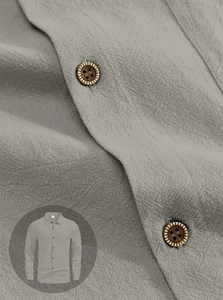 Detail of grey linen shirt fabric texture and natural wood grain buttons on sleeve
