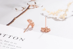Macro shot of rose gold Tree of Life stud earrings with delicate zircon pavé details
