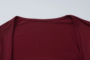 Détail de l'encolure en dentelle et texture du tissu rouge vin avec double surpiqûre