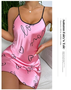 Détail d'une nuisette en satin rose avec bordure noire et motif d'amour et de cœur