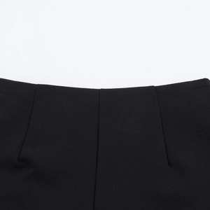 Detailansicht der schwarzen Shorts mit Metallkette, Falten-Design und feiner Nahtverarbeitung