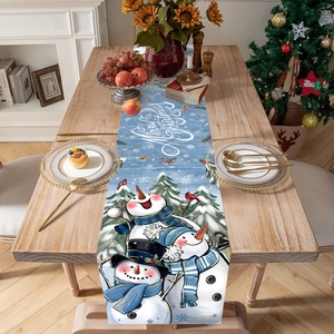 Blue Christmas table runner with three snowmen and Merry Christmas text on wooden table