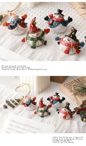 Close-up of resin Christmas miniatures with snowman and tree on white knit background