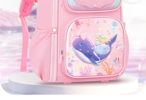 Macro view of pink dreamlike schoolbag featuring glittery girl and whale illustration