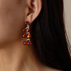 Detail view of vintage amber resin bead cluster earrings on model for an elegant look