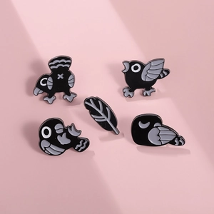 Lot de 5 broches en émail oiseaux noirs et plume sur fond rose de style dessin animé